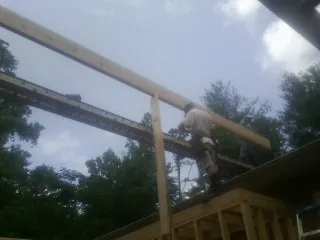 Carpenter setting a ridge beam over a new addition frame — Ice Dam Removal by Roofing Brothers in Fort Mill