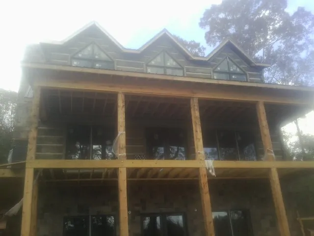 Dormers and porch framing on a large log home under construction — Roof Coating work by our crew in Fort Mill
