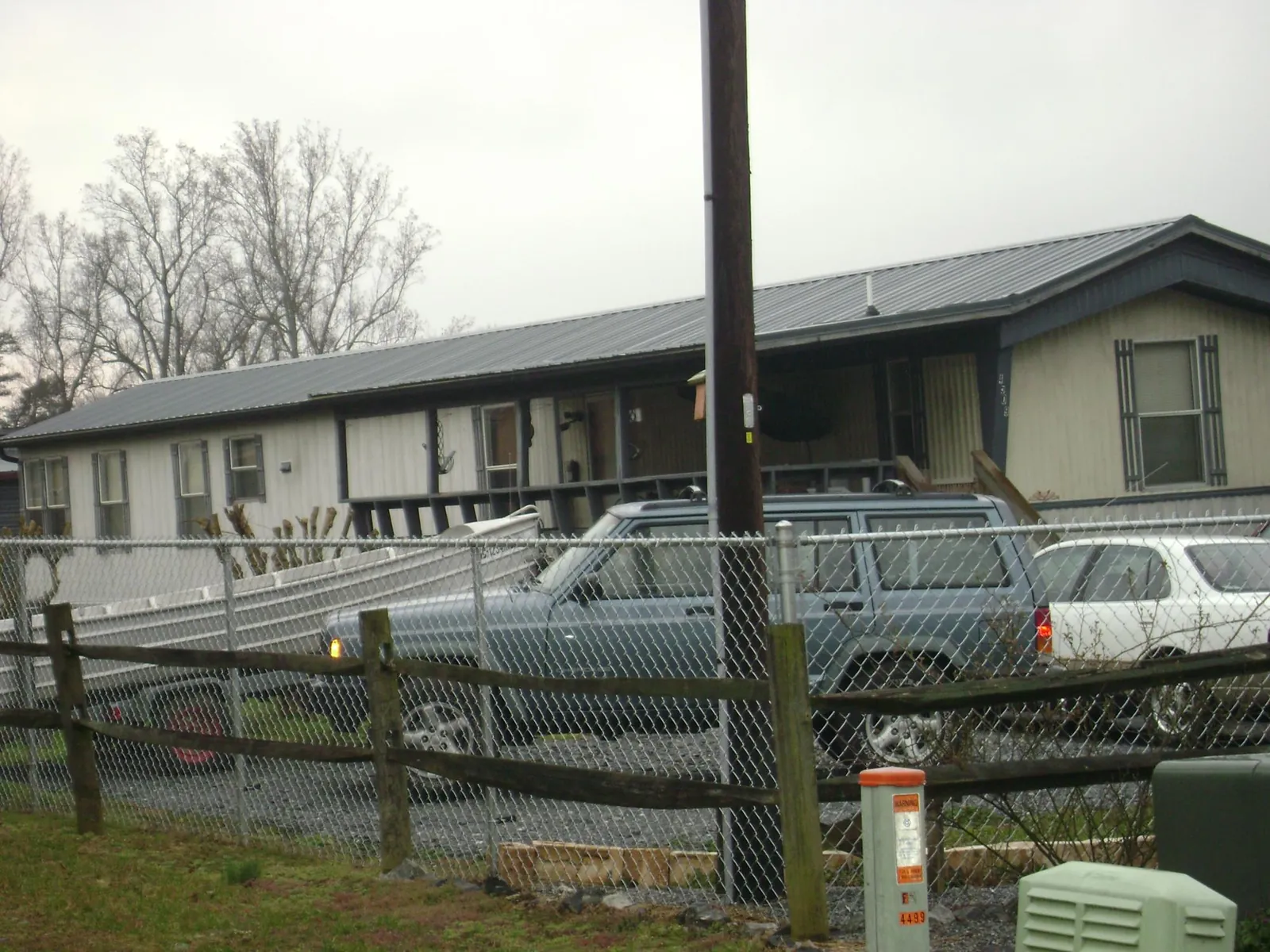 Dark metal roof on a long single story building behind a chain link fence in Fort Mill