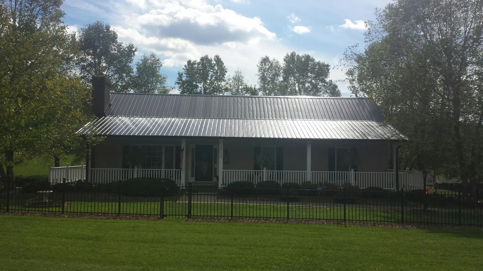 Gray metal roof on a brick ranch with a full width front porch — Gutter Guard Installation work by our crew in Fort Mill