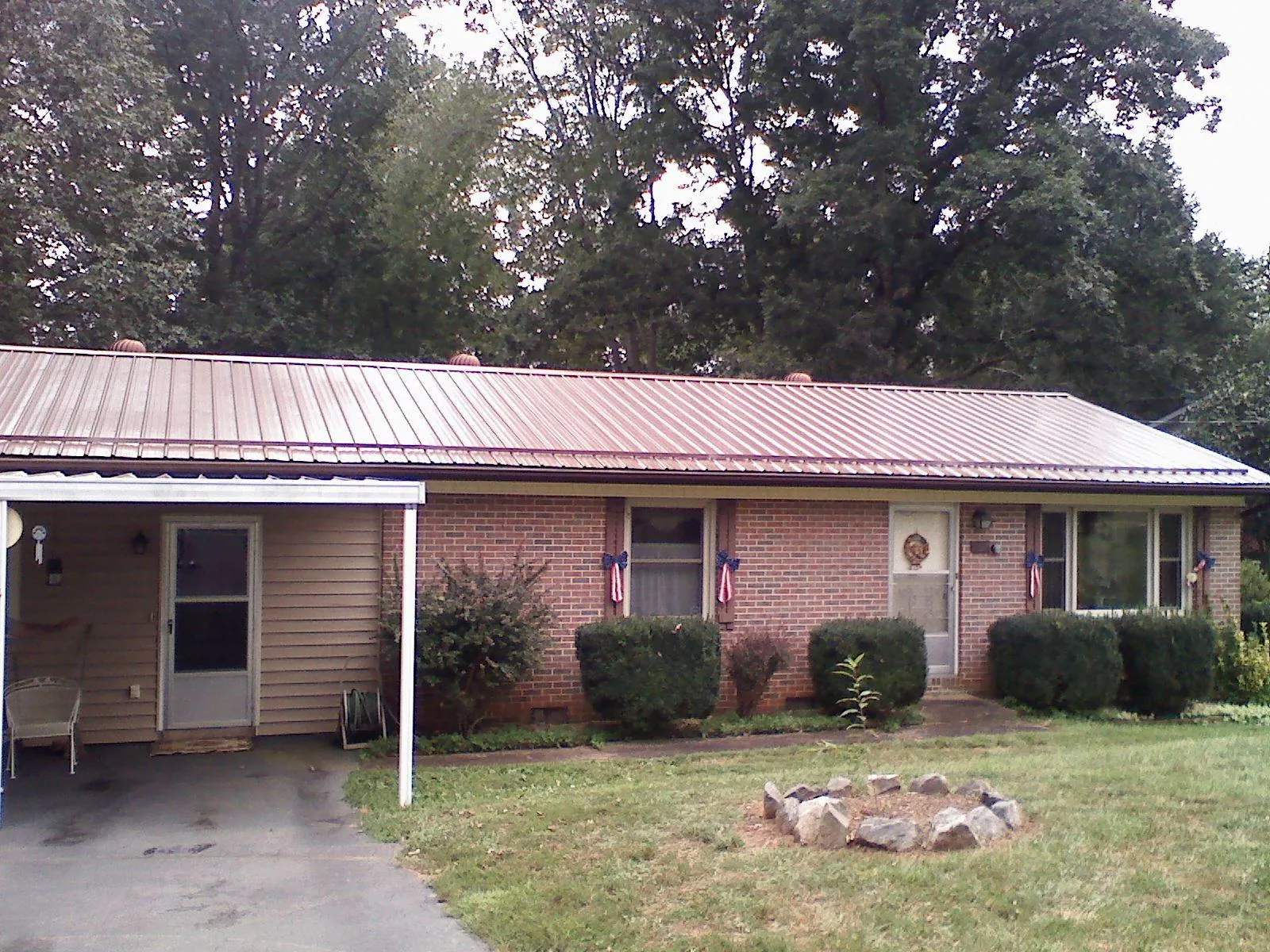 Bronze metal roof and carport on a brick ranch home — Roof Repair work by our crew in Fort Mill